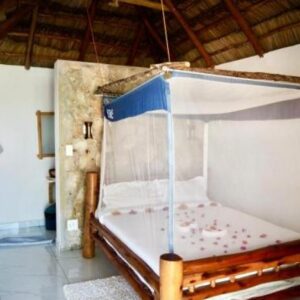 Спальня Bush Beach Hostel с кроватью с балдахином и москитной сеткой, Bairro Desse, Виланкулу, Мозамбик