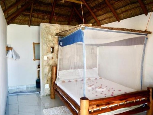 Chambre de Bush Beach Hostel avec lit à baldaquin et moustiquaire, Bairro Desse, Vilanculos, Mozambique