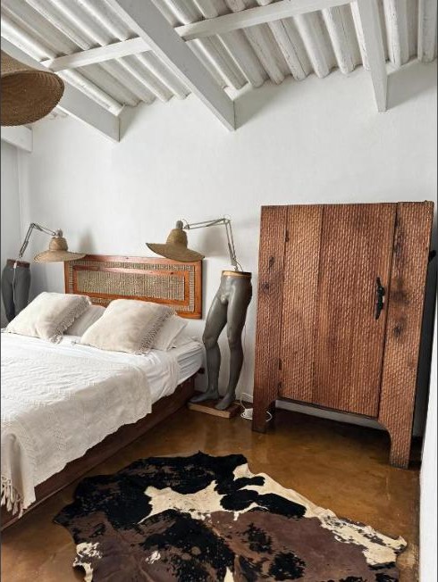Chambre avec meubles en bois et tapis en peau de vache à Casa Vermelha, Tofinho South Road, Praia do Tofo, Mozambique