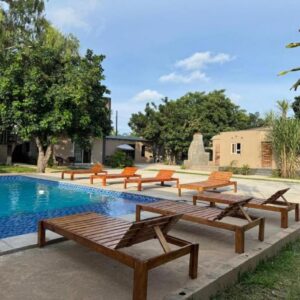 Piscina exterior com espreguiçadeiras e jardim no Comfort Inn Guest House, Chiango, Maputo, Moçambique.