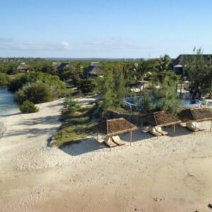 Sonnenschirme am Strand, Pool und strohgedecktes Haupthaus der Coral Lodge nahe der Ilha de Moçambique