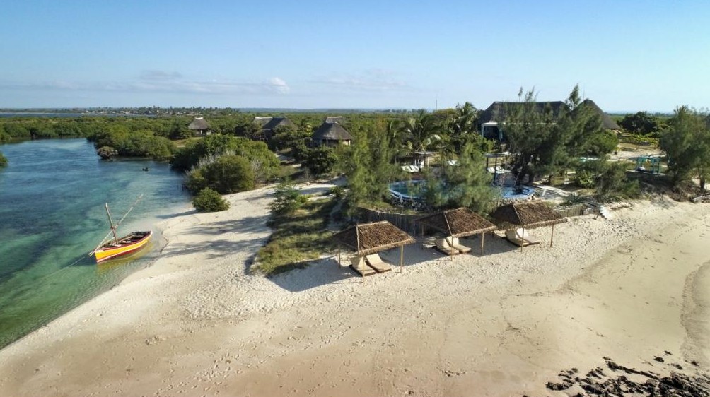 Sonnenschirme am Strand, Pool und strohgedecktes Haupthaus der Coral Lodge nahe der Ilha de Moçambique