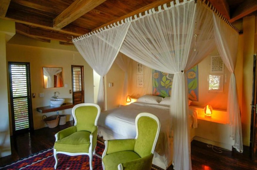 Chambre avec lit à baldaquin et moustiquaire à Ebony Beach, Vilanculos