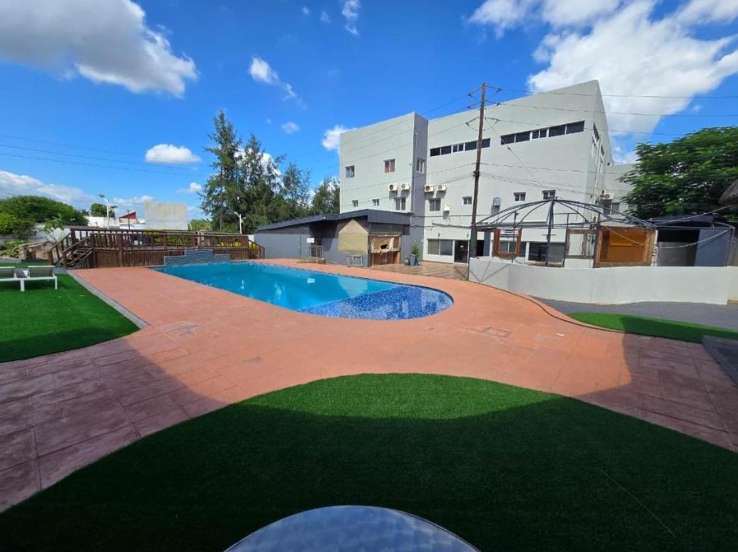 Pool und Hotelgebäude von Hotel Izzy Stay, Matola