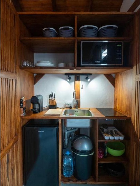 Índico Breeze自助式小屋的小厨房,配有木制橱柜,莫桑比克托福海滩托福市场后面
