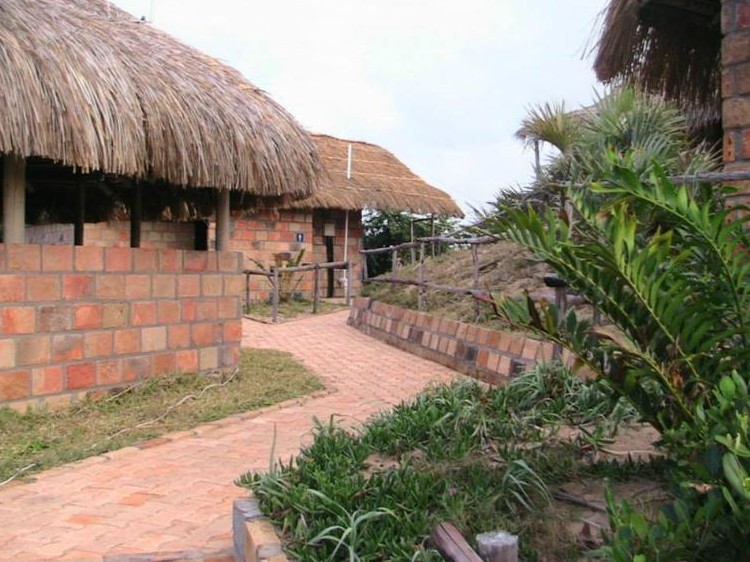 Gemauerte Chalets mit Reetdach und gepflasterter Weg im Island Rock Resort