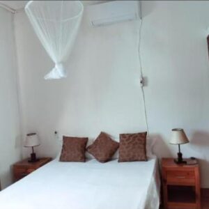 Landa's Guest House配有蚊帐的双人卧室，莫桑比克托福海滩 Rua Josina Machel