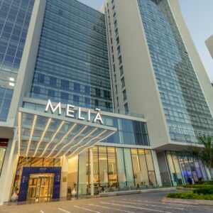 Modern Meliá Maputo Sky hotel entrance with glass facade and illuminated sign, Maputo