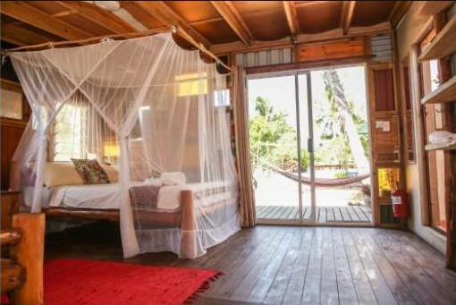 Camera del bungalow con zanzariera e veranda in legno presso Mozambeat Motel, Bairro Josina Machel, Praia do Tofo, Mozambico