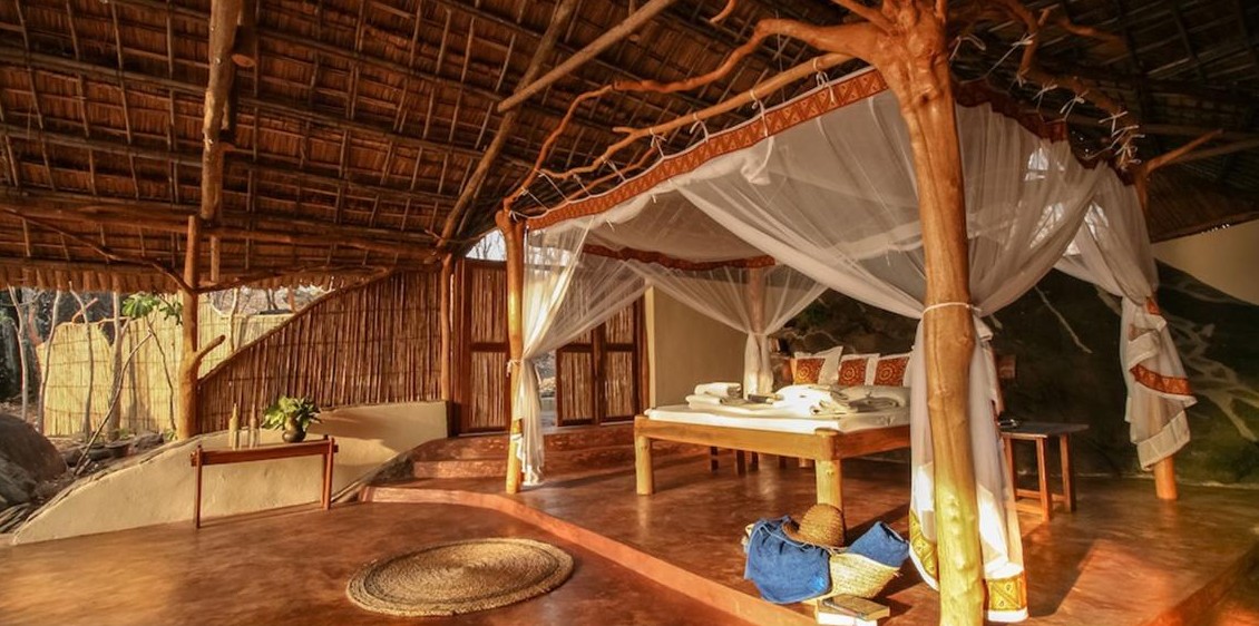 Seitlich offenes Chalet mit Reetdach und Himmelbett im Nkwichi Lodge, Niassasee