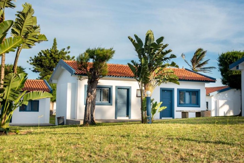Белые шале с синей отделкой на лужайках Ponta Mar Resort, Понта-ду-Оуру