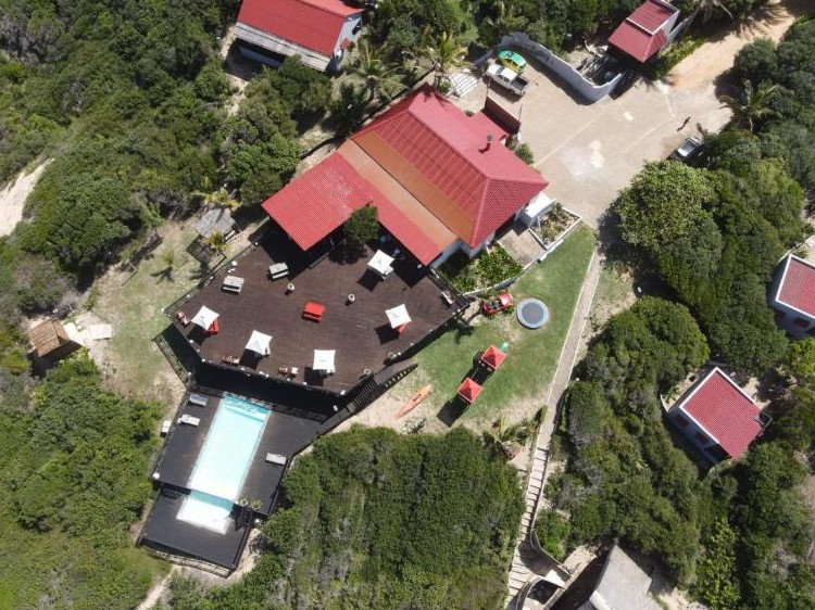 Vista aérea do edifício principal, do deque e da piscina do Sunset Beach Resort, Chidenguele