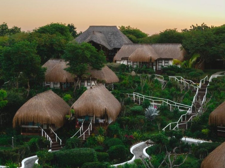 Vilanculos Beach Lodge山坡花园中的茅草顶豪华平房